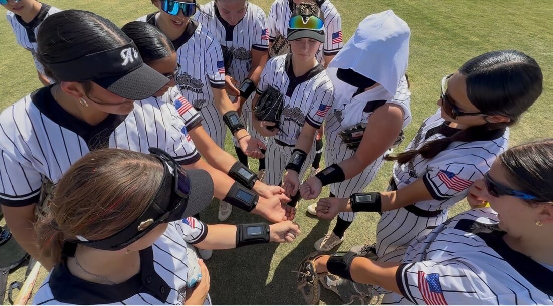 Football players checking wristbands in the huddle